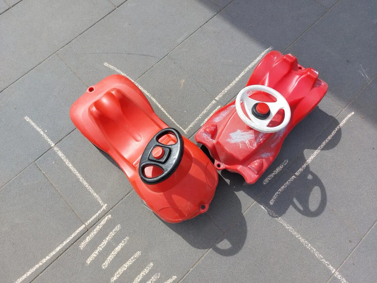 Zwei Spielzeugautos sind auf einer Kreidekreuzung zusammengestoßen