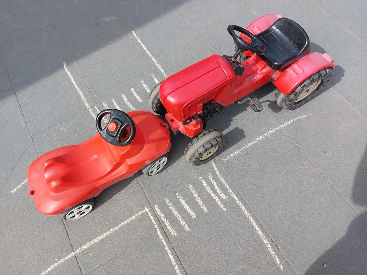 Spielzeugtraktor und Spielzeugauto nach einem Zusammenstoß