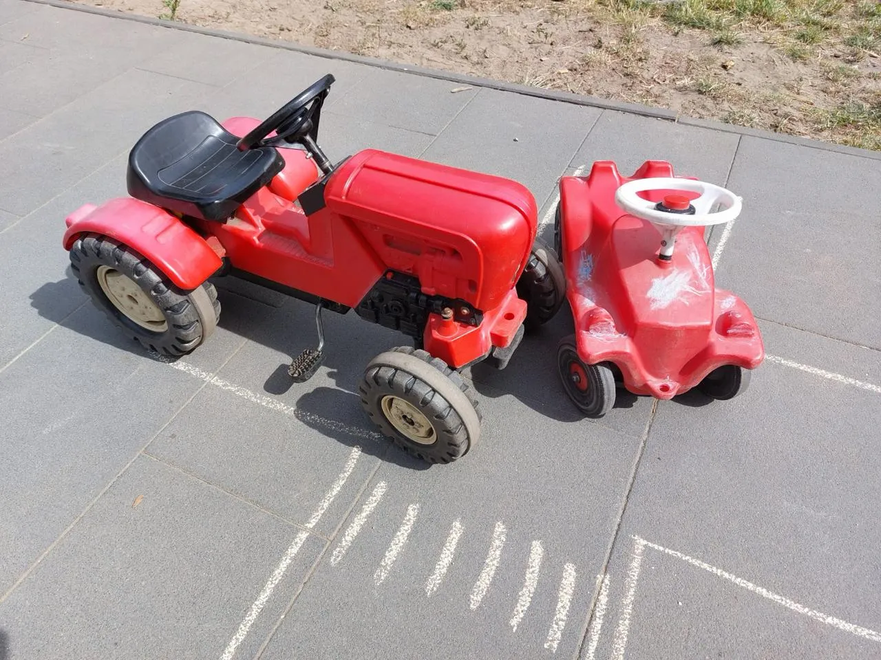 Spielzeugtraktor schiebt ein Spielzeugauto