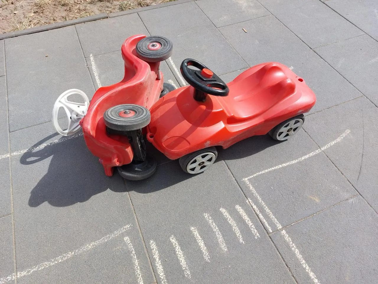 Umgekipptes Spielzeugauto neben einem zweiten